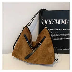 Detalle del bolso tote de ante color caramelo con correas de cuero y anillas doradas