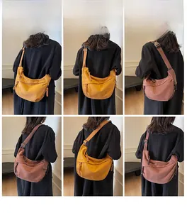 Vues détaillées du sac bandoulière croissant en toile jaune gingembre et rouge brique