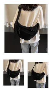 Detail of black pleated crescent bag featuring durable canvas fabric and adjustable wide strap