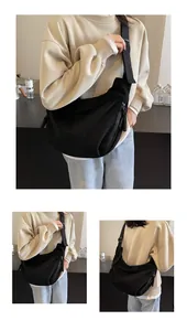 Vues détaillées du grand sac bandoulière noir en forme de croissant avec sangle large