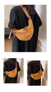 Detail of vintage brown crescent bag with woven zipper pull and adjustable strap