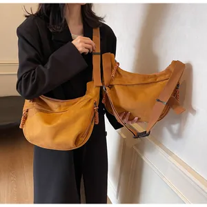 Détail du sac à bandoulière avec large sangle et fermeture éclair à glands tressés