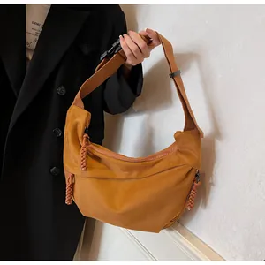 Détail du sac croissant jaune montrant la bandoulière large et le tire-zip tressé
