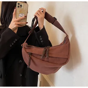 Detail of dark brown hobo bag with thick braided zipper pull and wide adjustable strap