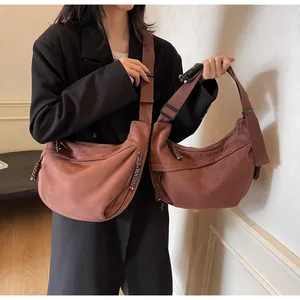 Comparaison de deux tailles de sacs bandoulière demi-lune rouge brique au style épuré