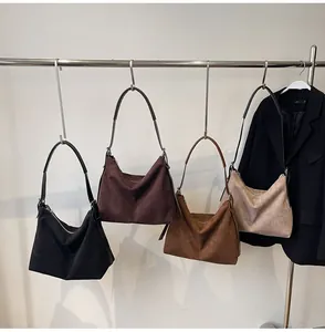 Détail de quatre sacs fourre-tout mats en noir, marron, caramel et beige sur support