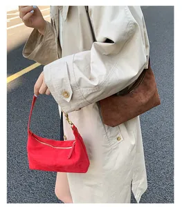 Close-up of minimalist suede tote bags in red and brown with matte texture details