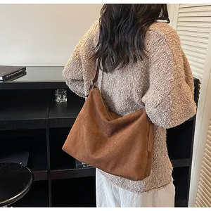 Gros plan du sac hobo en daim marron avec texture mate et détails de fermeture éclair