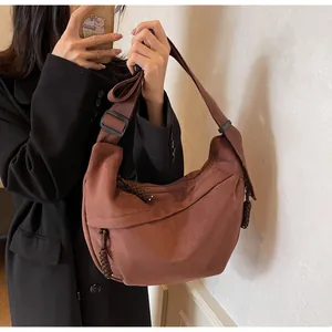 Détail du sac bandoulière croissant en toile marron caramel avec tirette de zip tressée