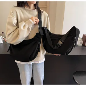 Comparaison de grands et petits sacs bandoulière noirs en forme de croissant sur un mannequin