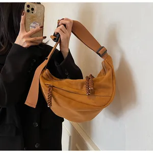 Detail of caramel suede hobo bag with braided knots and adjustable wide shoulder strap