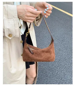Detailed macro view of the brown suede surface and gold metal buckle on a retro handbag