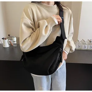 Détail de la grande sacoche noire en forme de croissant montrant sa texture en toile