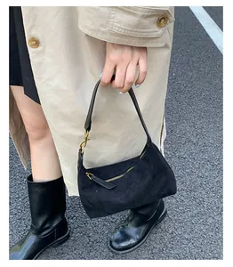 Detail of black faux suede tote bag with gold zipper and minimalist urban street style