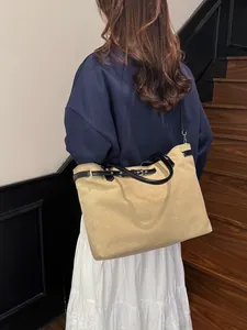 Large khaki canvas tote bag with black leather straps and silver buckle detail