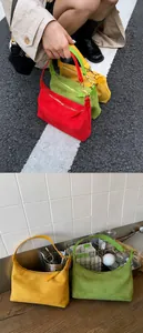 Detailed view of suede hobo bags in red, green and yellow with golden zip closure