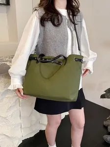 Large army green canvas tote bag with black leather handles for versatile daily commute