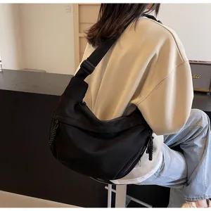 Détail du sac bandoulière croissant en nylon noir avec tirette tressée et large sangle