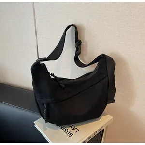 Sac bandoulière minimaliste noir en nylon style besace avec large bandoulière ajustable