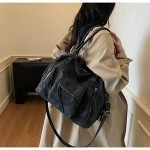 Dettaglio della borsa tote vintage grigio scuro con design multitasche e trama opaca