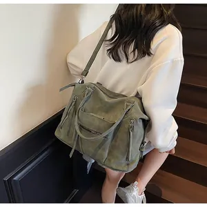 Dettaglio della borsa tote vintage con manici intrecciati e frange su camoscio verde