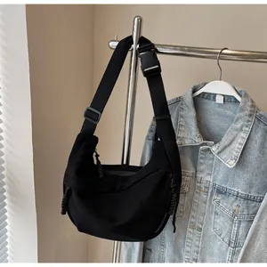Détail du sac bandoulière croissant en nylon noir avec sangle et fermeture éclair