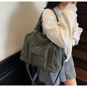 Dettaglio della borsa tote vintage verde scuro con nappe decorative e texture opaca