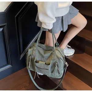 Dettaglio della grande borsa tote vintage verde oliva con tasche multiple su scale