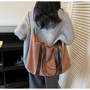 Brown canvas tote bag with leather straps shown on a model for daily commute use