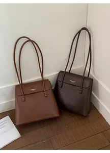 Detail of vintage tote bags in brown and dark coffee with pebbled leather and ball charm
