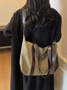 Large olive canvas tote bag with brown leather straps shown on a model's shoulder