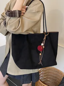 Large black suede tote bag for women with long shoulder straps and tassel pendant charm