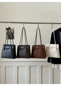 Detail of four colorful faux leather tote bags with bead trimming and flap closure