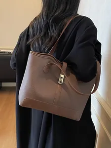 Minimalist taupe pebbled leather tote bag with brown straps and golden square lock detail