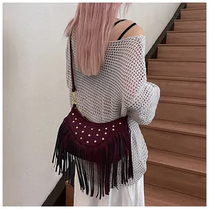 Détail du sac à bandoulière bordeaux avec clous dorés et longues franges bohèmes