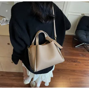 Detail of beige lychee grain bucket bag with gold hardware and adjustable strap