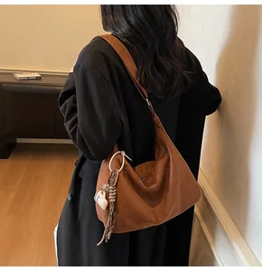 Bruine grote suède hobo tas gedragen door een vrouw voor een chique kantoorlook