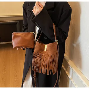 Détails d'un sac seau en daim à longues franges et pochette assortie en marron foncé