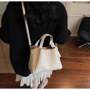 Close-up of creamy white lychee-patterned leather bucket bag with dual handles