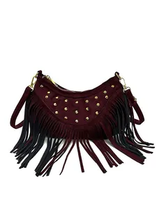 Sac bandoulière demi-lune bordeaux avec clous dorés et longues franges sur fond blanc