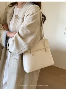 Detail of cream leather bucket bag showing lychee grain texture and bead accents