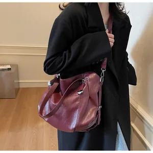 Close-up of wine red soft leather tote bag showing pleated details and silver hardware