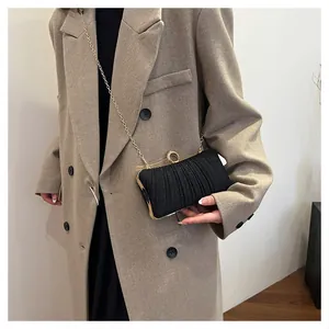 Détail de la pochette de soirée plissée noire en tissu pailleté et fermoir strass