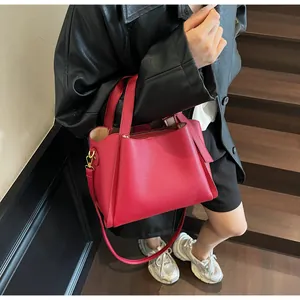 Close-up of red lychee pattern leather handbag with metal zipper and dual top handles