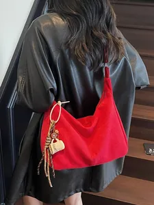 Grote rode suède hobo tas met koffiekopje hanger gedragen door model op de trap