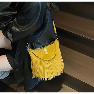 Gros plan d'un sac seau en daim jaune avec franges et fermoir doré vintage