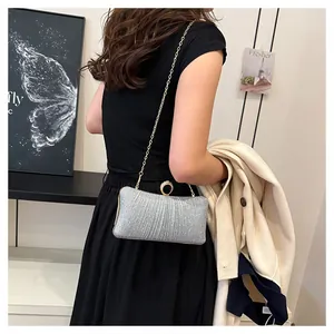 Détail de la pochette de soirée à paillettes argentées avec texture plissée et chaîne