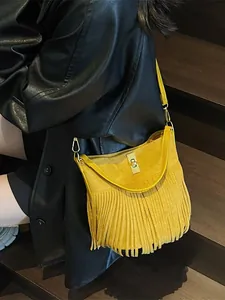 Sac seau bohème en daim jaune à franges avec fermoir doré porté par un mannequin en cuir