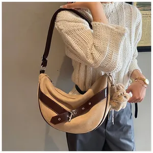 Detail van kaki suède hobo tas met verstelbare riem en pluche beer hanger decoratie