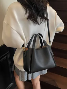 Elegant black lychee texture bucket bag with gold hardware shown on a model